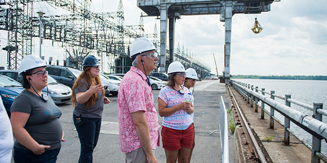 Visiteurs et visiteuses admirant la rivière à partir du toit de la centrale.