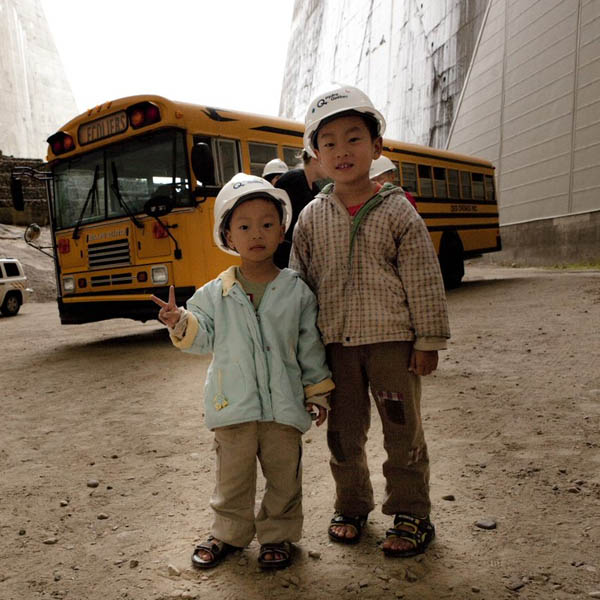 Enfants devant un autobus sous une voûte du barrage Daniel-Johnson.