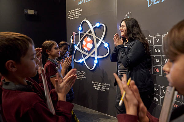 Guide et visiteurs devant un atome à l'Électrium