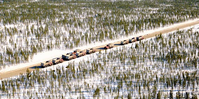 Vue aérienne d’un convoi de camions pendant la construction de la route de la Baie-James.