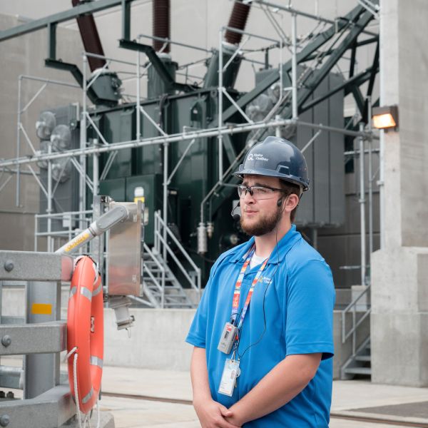 Guide devant un transformateur de la centrale de la Romaine-1.