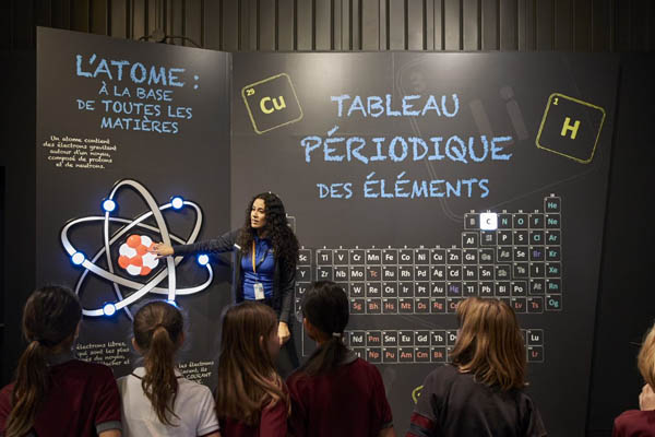 Guide expliquant l’atome à des élèves à l’Électrium.